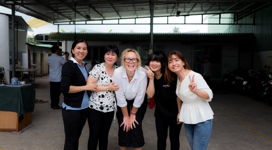 Women at a factory in Vietnam smiling at camera