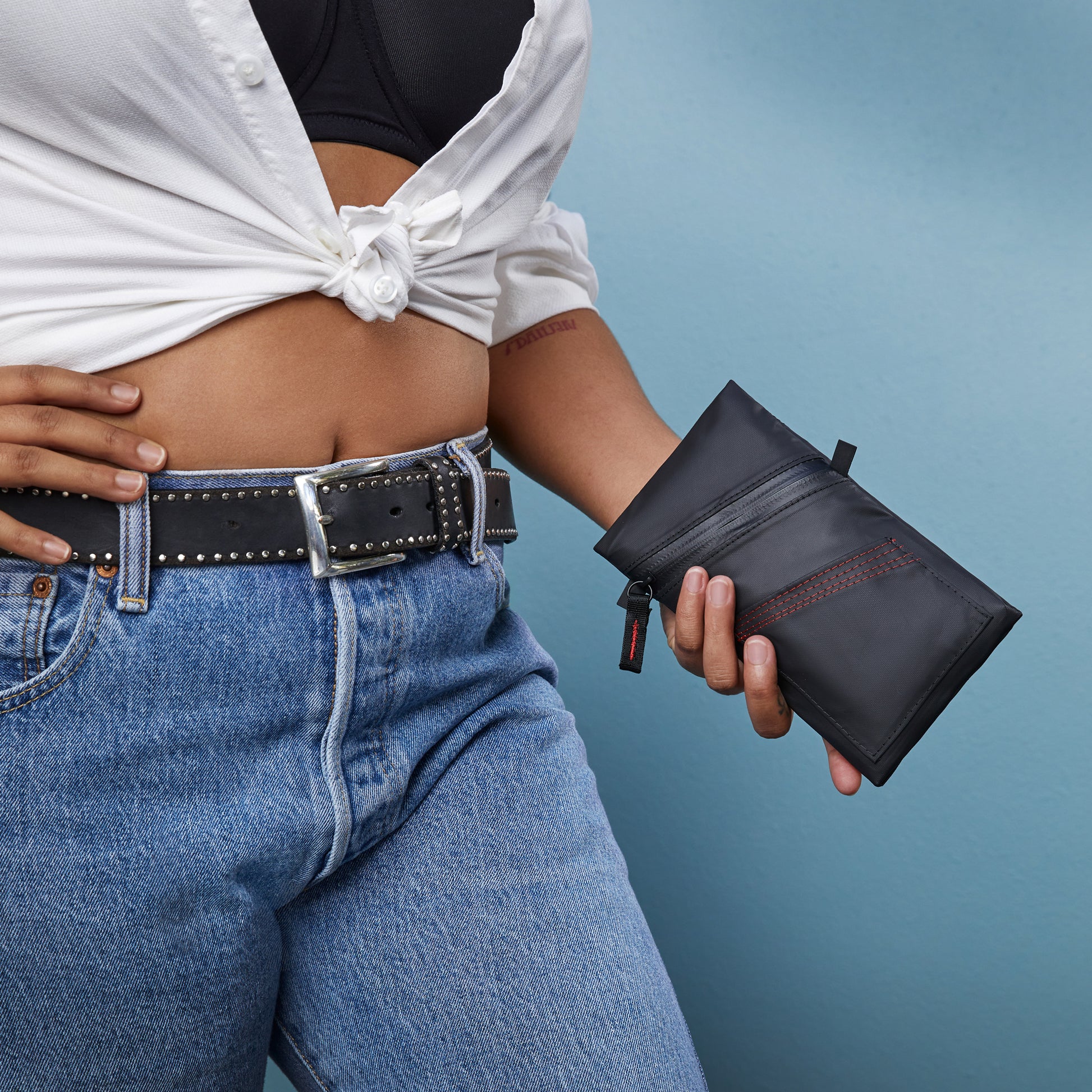 Woman holding Fierce Hazel Echelon Pouch in Ballistic black. Cycling ride pouch weatherproof durable rainproof phone cycling wallet